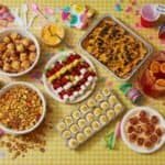 Colorful party food assortment with snacks, desserts, and drinks for a fun celebration.