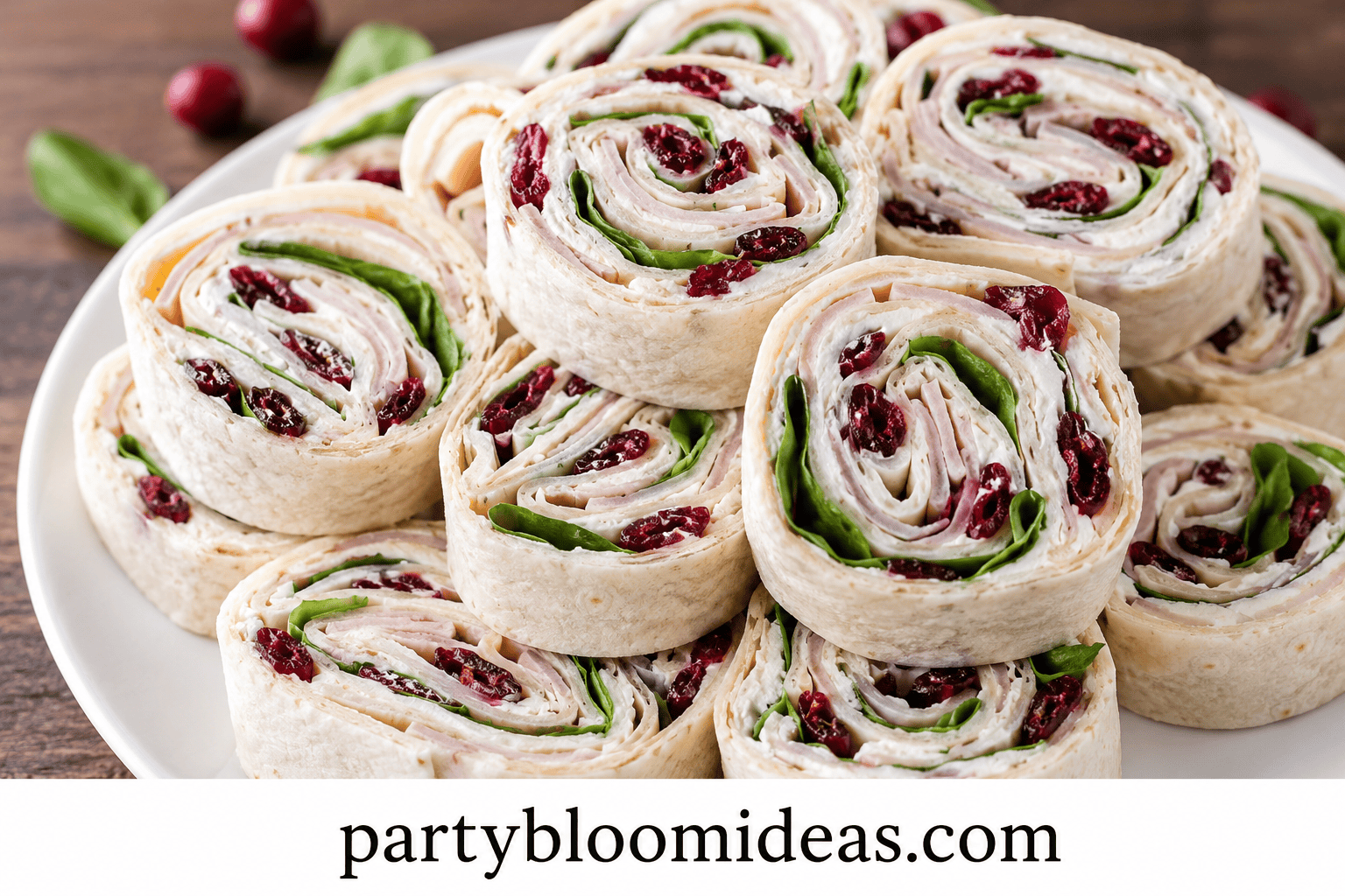 Turkey, spinach, and cranberry pinwheels sliced into spirals on a platter