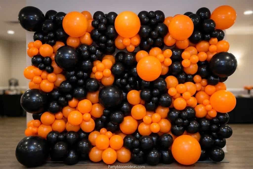 Black, orange, and purple balloon wall created from Dollar Tree supplies forming a dramatic Halloween photo backdrop.