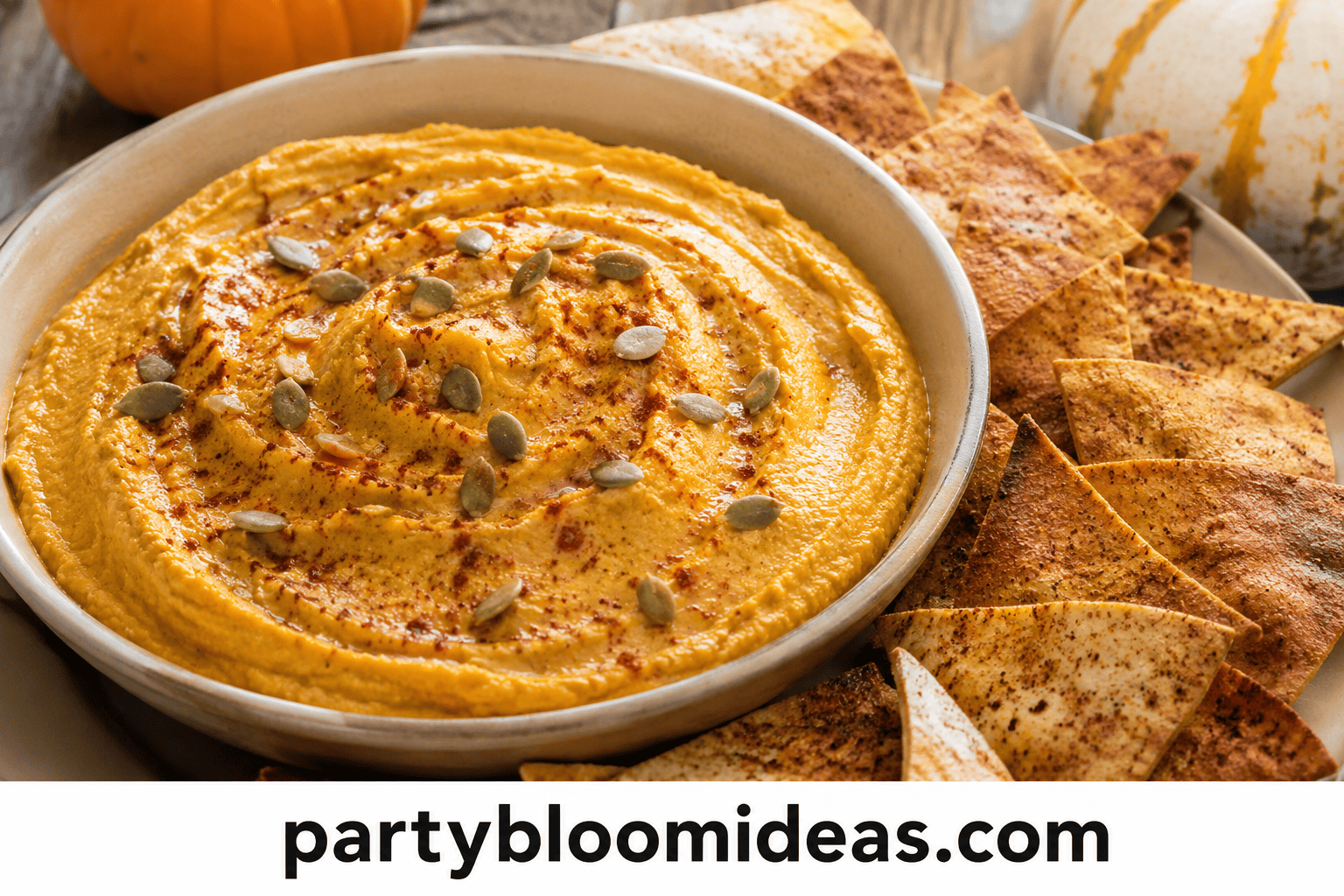 Pumpkin hummus garnished with seeds and served with crispy spiced pita chips