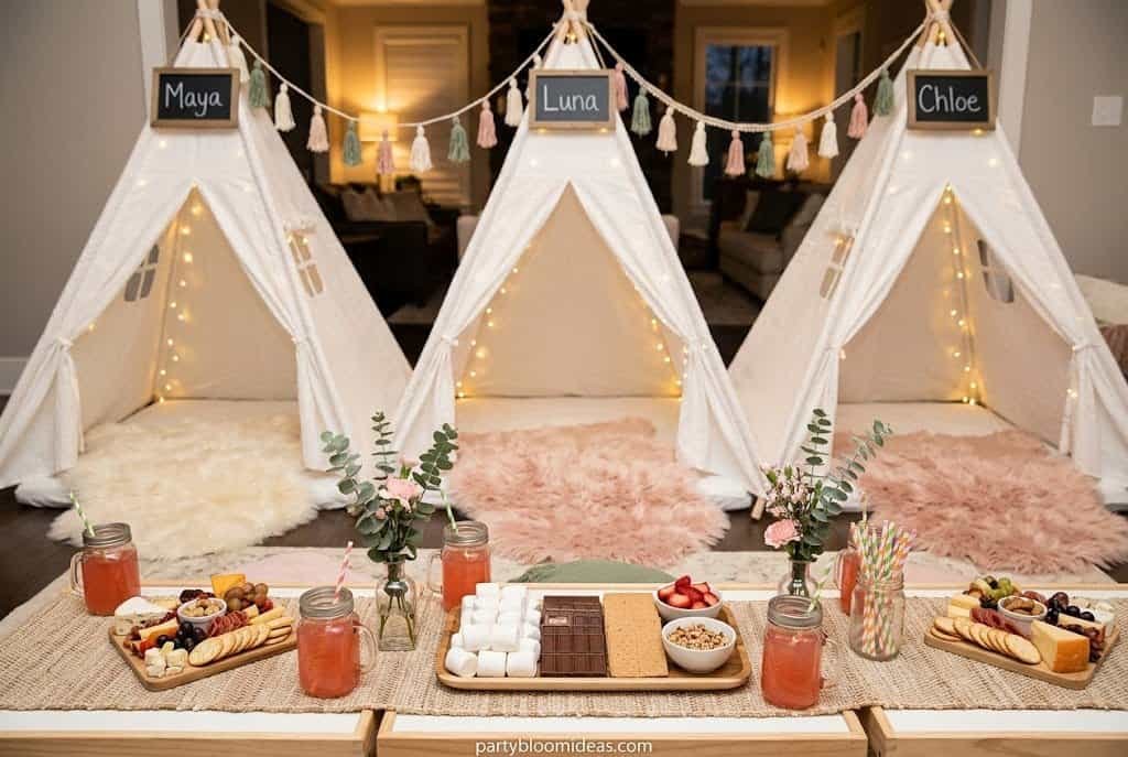 Boho glamping birthday party with white teepees, fairy lights, blush pillows, and plush rugs