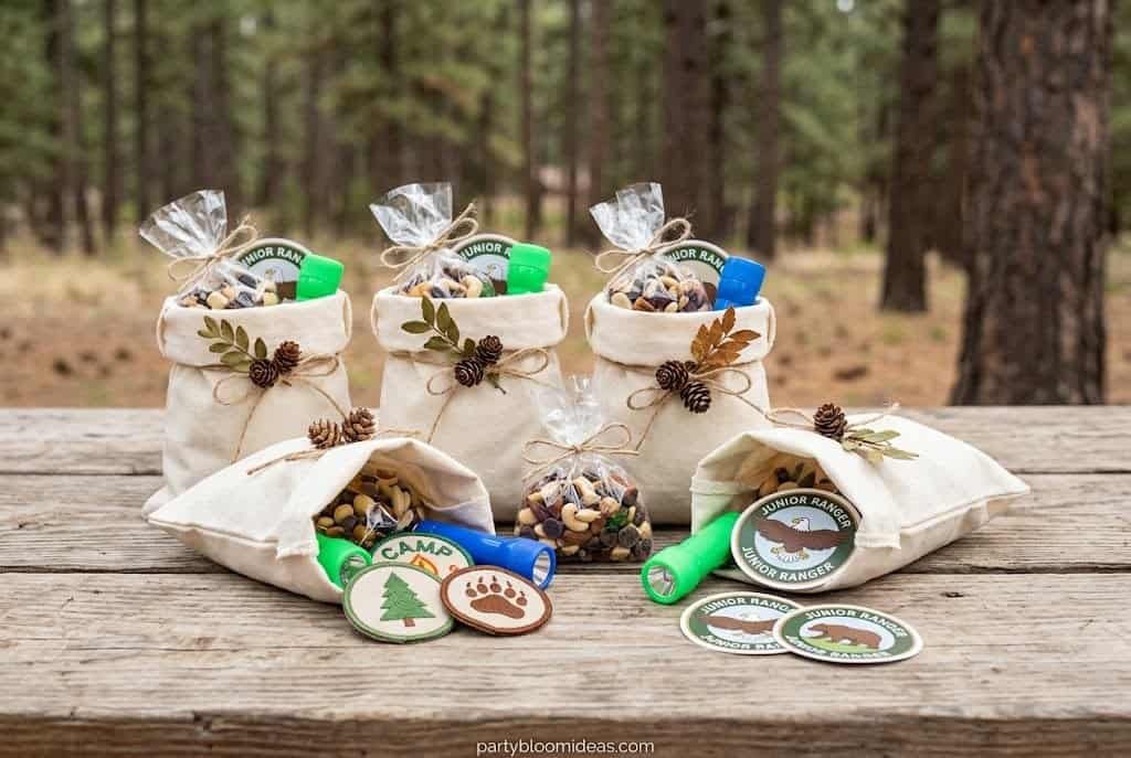 Camping birthday party favor bags with trail mix, flashlights, badges, and ranger certificates