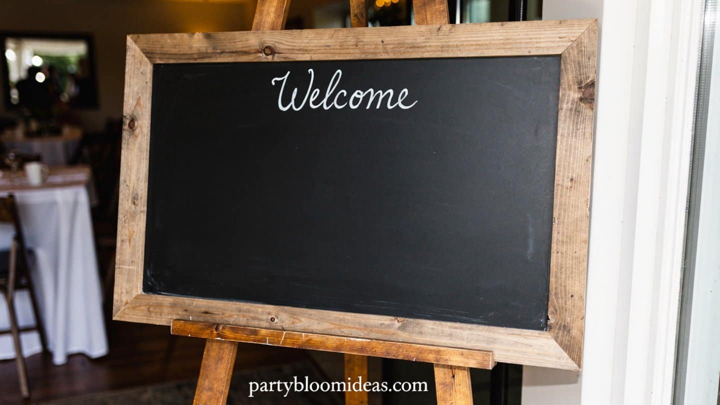 Rustic chalkboard welcome sign in a wooden frame at a party entrance