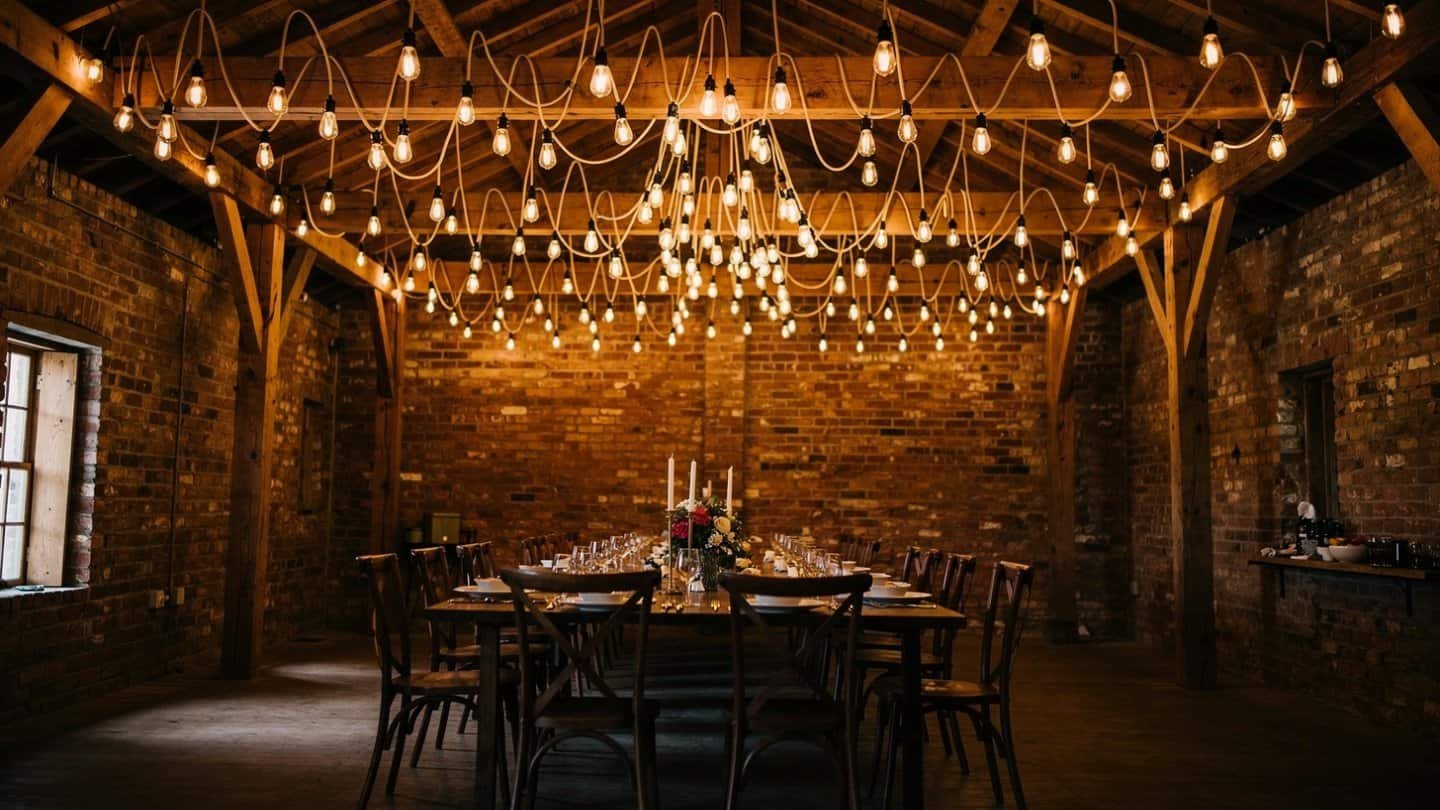 Rustic event space with warm Edison string lights draped across the ceiling