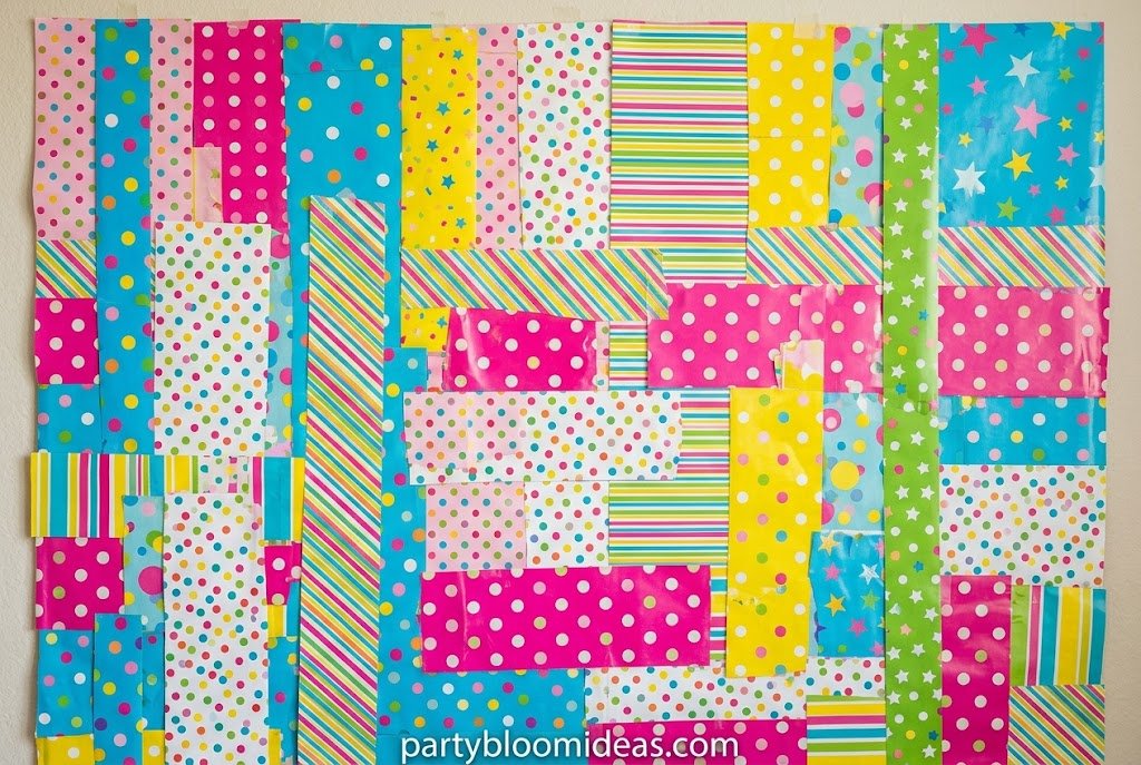 Budget-friendly DIY photo booth made with decorative wrapping paper backdrop, personalized banner, and simple lighting for last-minute party photo opportunities DIY Photo Booth Ideas for Any Party