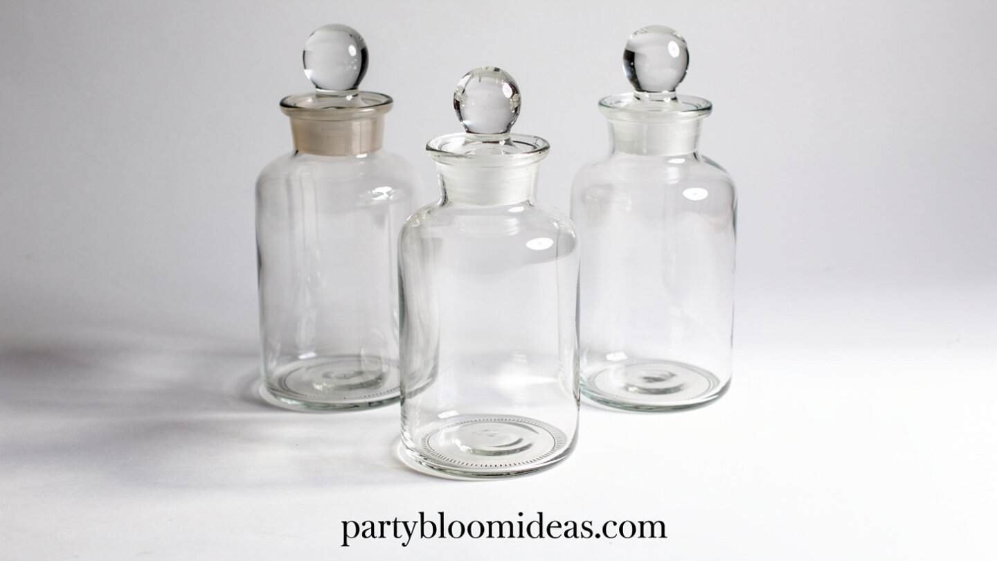 Glass apothecary jars filled with candy corn, pinecones and cinnamon sticks