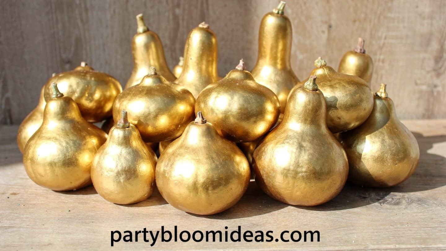 Gold dipped gourds arranged on mirrored tray Thanksgiving centerpiece