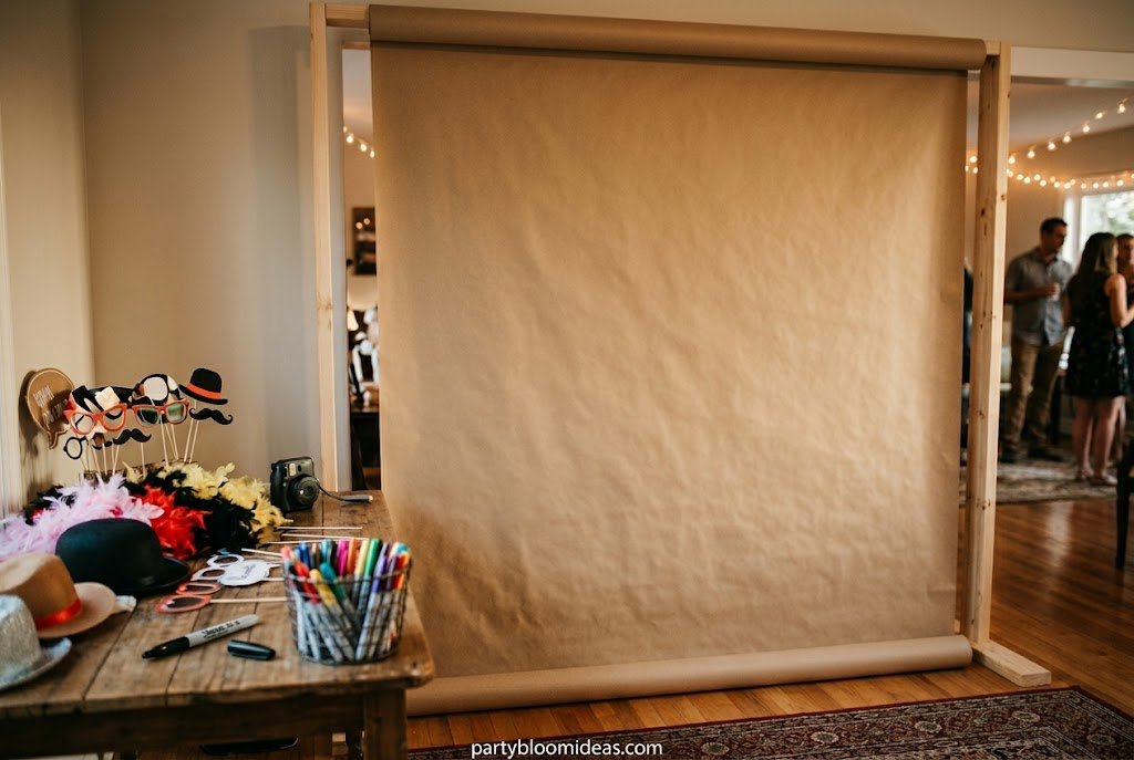 Interactive kraft paper photo booth backdrop covered with handwritten messages, doodles, and signatures, perfect for kids' parties and casual celebrations.