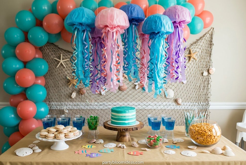 Under the Sea first birthday party theme with ocean decorations, jellyfish, and sea colors